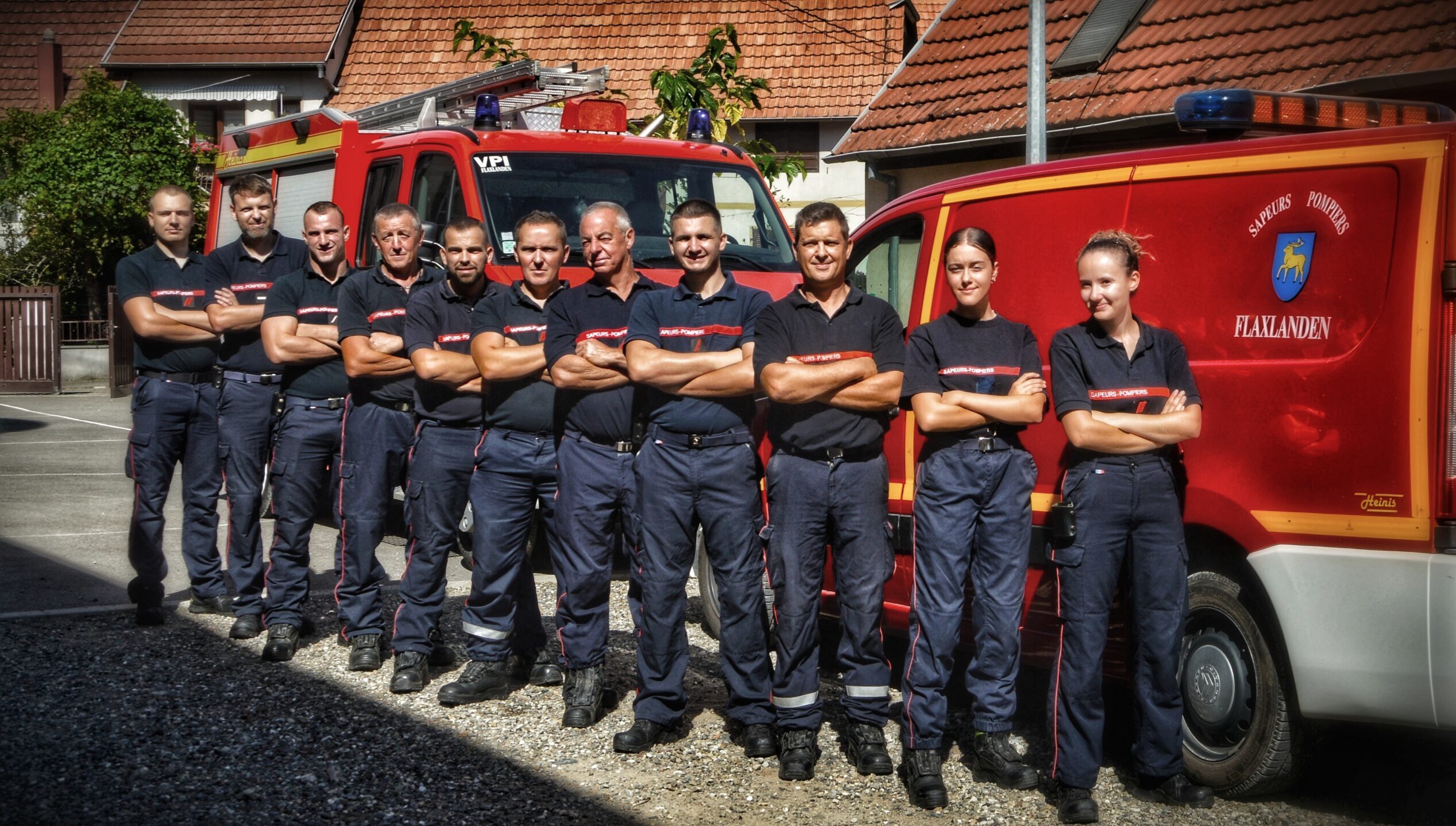 Le corps des Sapeurs-Pompiers de Flaxlanden devant leurs camions